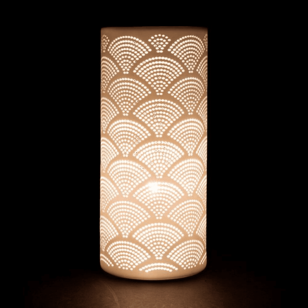 Lampe allumée en forme de cylindre blanc avec motifs sur fond noir