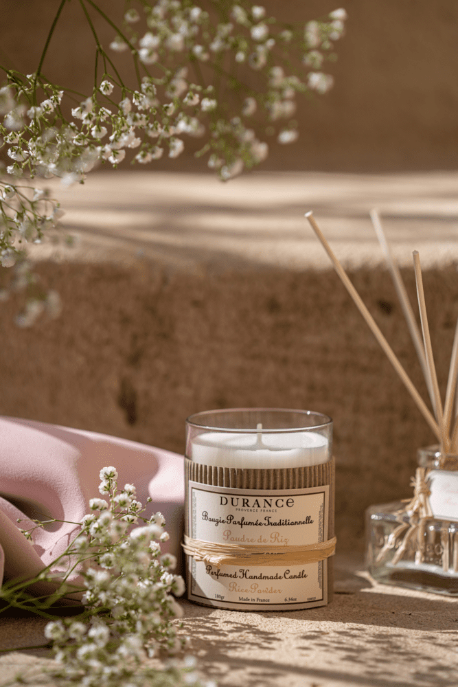 bougie artisinale Poudre de riz sur un fond ambiance été avec des fleurs