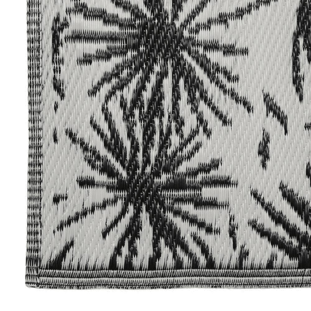 Tapis plié noir et écru avec des motifs sur fond blanc